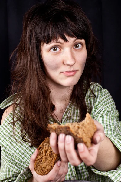 Нищая женщина с куском хлеба в руках — стоковое фото