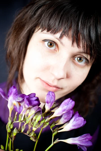 Vrouw met paarse bloemen — Stockfoto