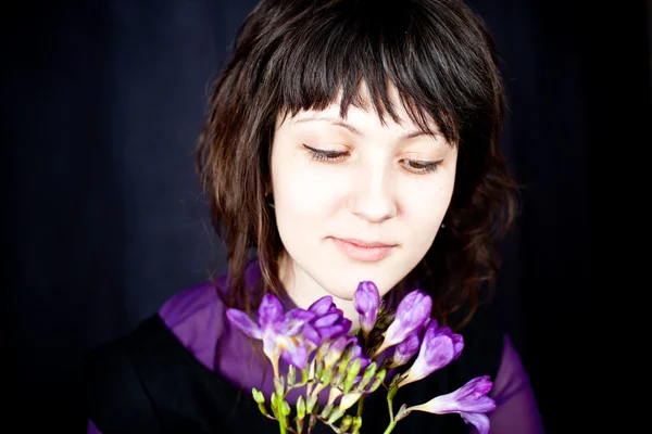 Beautiful woman with purple flowers — Stock Photo, Image