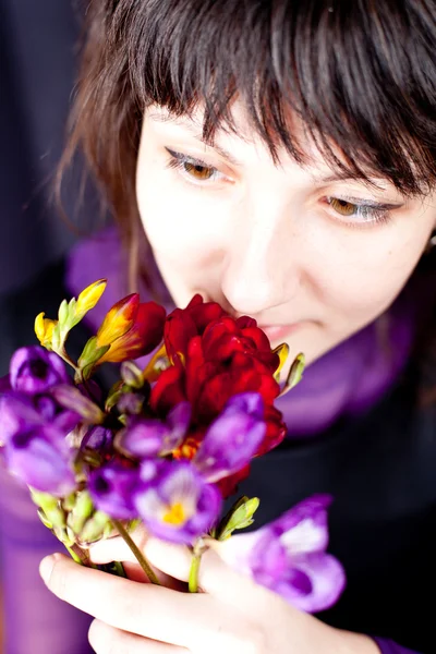 Kobieta z purple i czerwone kwiaty — Zdjęcie stockowe