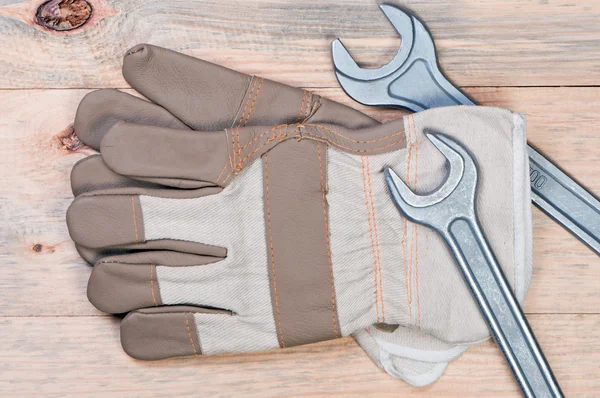 作業用手袋、木製の背景にレンチ. — ストック写真
