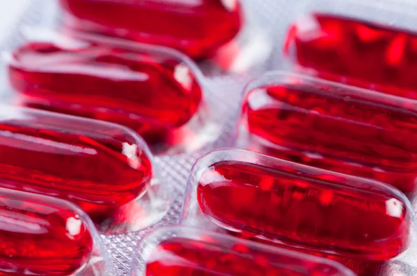 Pillole rosse in imballaggio da vicino . — Foto Stock
