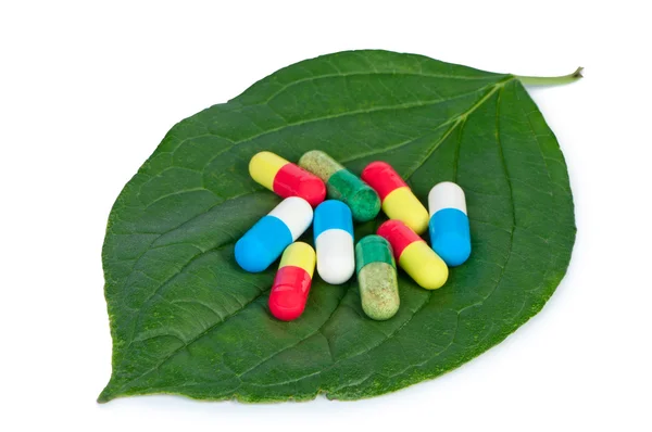 Tabletki na koncepcja liść na białym tle, medyczne. — Zdjęcie stockowe