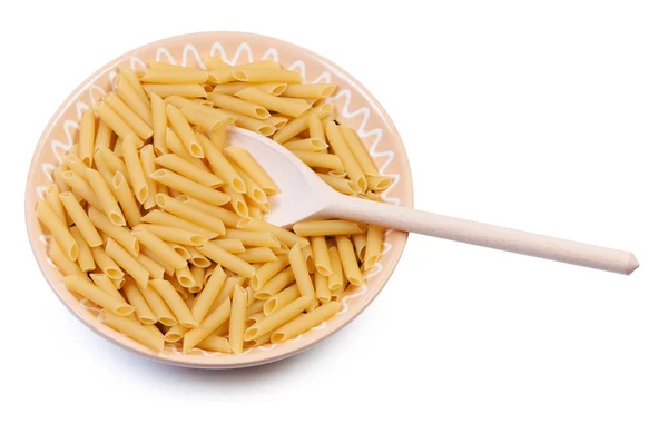Plate with raw pasta and wooden spoon on white background. — Stock Photo, Image
