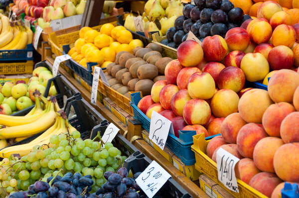 Fruit at market with price tags for sale.