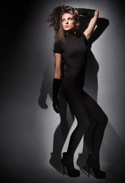 Junge schlanke Glamour-Lady mit langen Haaren in schwarzer Kombi — Stockfoto