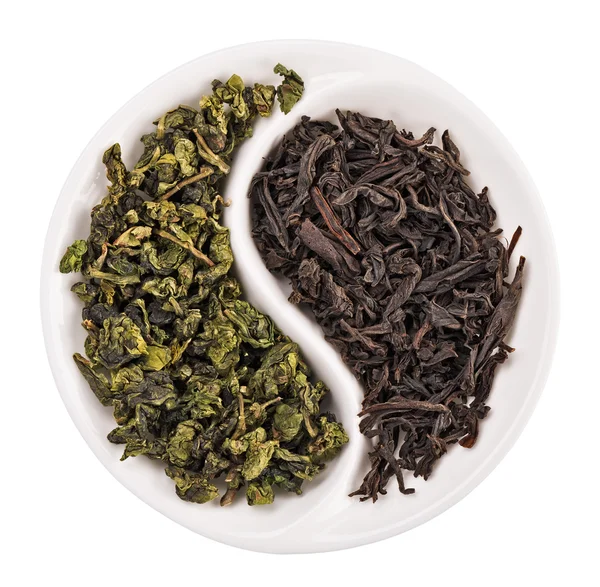 Green leaf tea versus black one in Yin Yang shaped plate, isolat — Stock Photo, Image