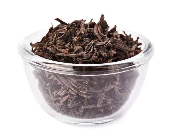 Black leaf tea heap in transparent glass bowl, isolated on white — Stock Photo, Image