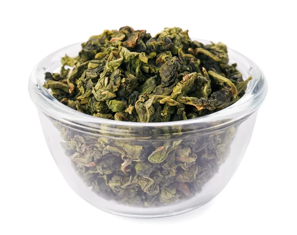 Zielony liść herbaty sterty w misce przezroczystego szkła, na białym tle — Zdjęcie stockowe