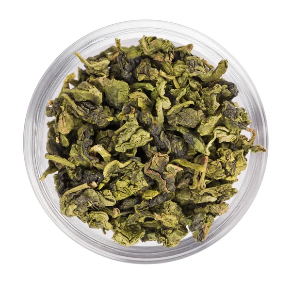 Zielony liść herbaty sterty w misce przezroczystego szkła, na białym tle — Zdjęcie stockowe