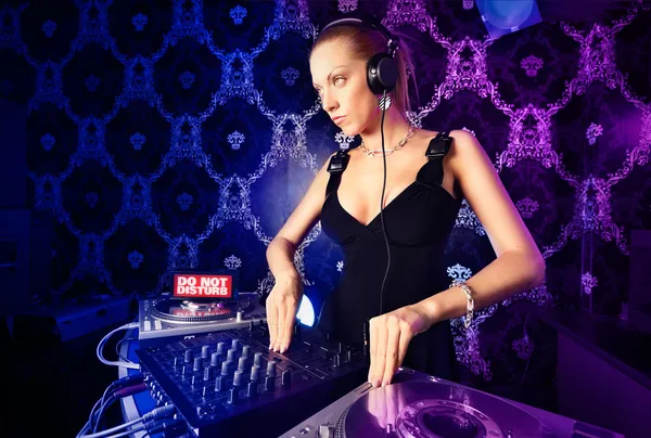 Sexy giovane bionda dj suonare musica in night club — Foto Stock