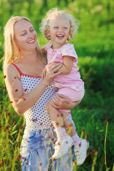 Vackra mamma med nyfödda lockigt-headed blonda dotter på mead — Stockfoto