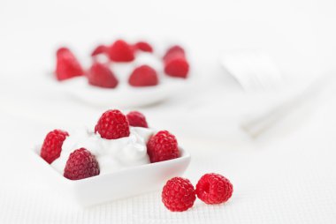Still life with raspberry sour cream dessert on white linen tabl clipart
