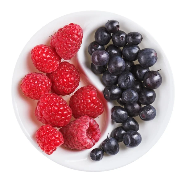 Red raspberry versus black bilberry in Yang Yin shaped plate, is — Stock Photo, Image