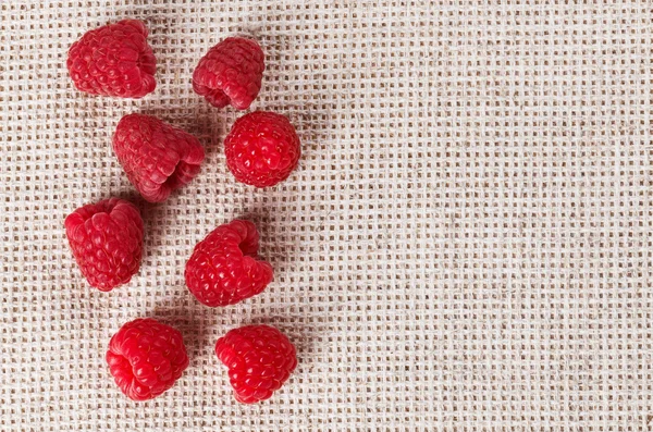 Many red ripe raspberry fruit, on gray linen table cloth with co — Stock Photo, Image