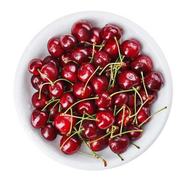 Viele rote Kirschfrüchte (Beeren) in rundem Teller, isoliert auf — Stockfoto