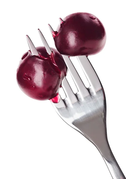 Dos frutas de cereza ensangrentadas pinchadas en tenedor de metal, aisladas en whit —  Fotos de Stock