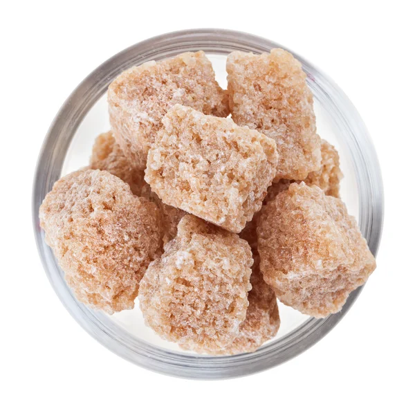 Hnědé kusové třtinový cukr ve skleněné míse, izolované na bílém — Stock fotografie