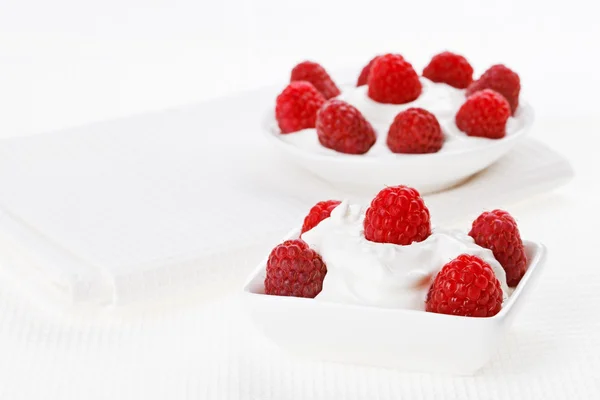 Натюрморт с малиновым десертом из сметаны на белом льняном столе — стоковое фото