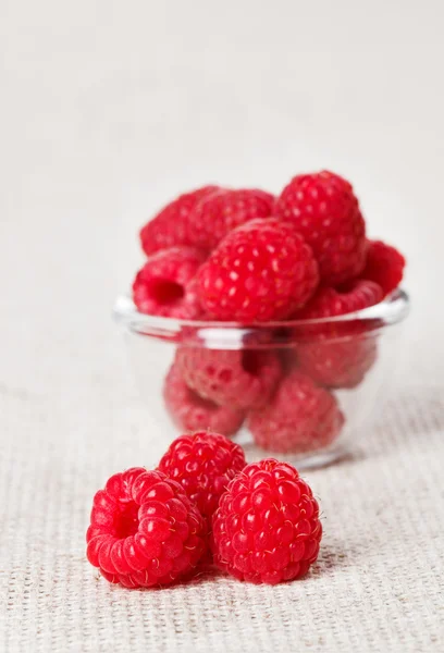 Still life with red raspberry and glass bowl on gray linen table — Stock Photo, Image