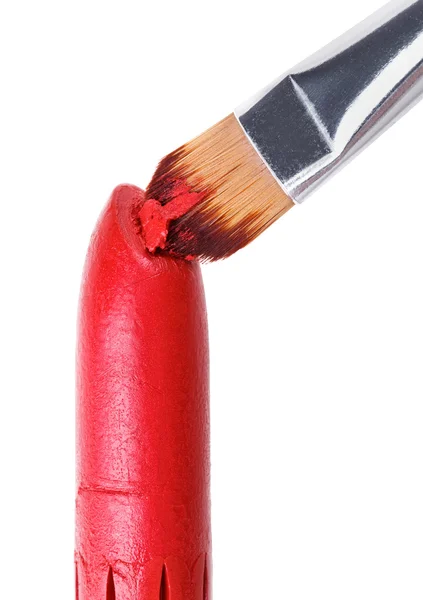 Cepillo de maquillaje empujado en lápiz labial rojo, aislado en blanco — Foto de Stock