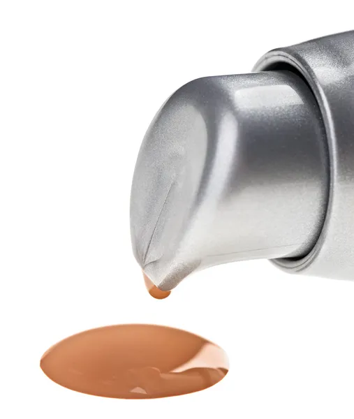 Crema de tono beige (base) gota de maquillaje derramada de la botella —  Fotos de Stock