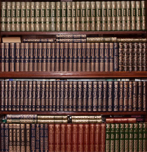Boeken in gouden dekking in bibliotheek — Stockfoto