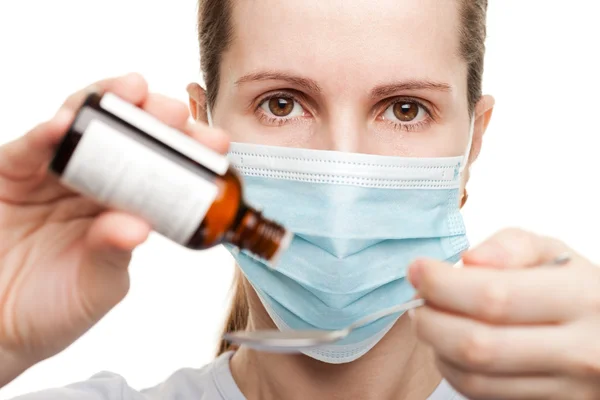 Doctor in de masker houden geneeskunde siroop — Stockfoto