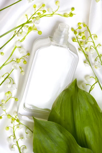 Lírio do vale e frasco de perfume em seda branca — Fotografia de Stock