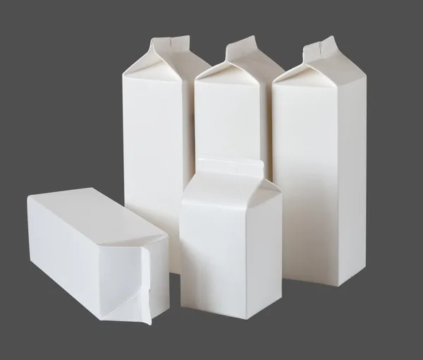 Пять молочных коробок на поллитра и литр на сером — стоковое фото