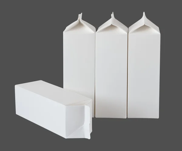 Quattro scatole di latte per litro e litro su grigio — Foto Stock