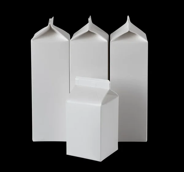 Четыре коробки молока на литр на черный — стоковое фото