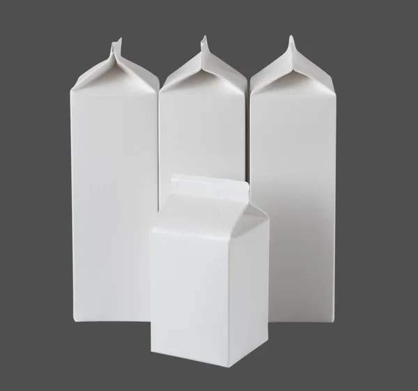 Четыре коробки молока на литр на сером — стоковое фото