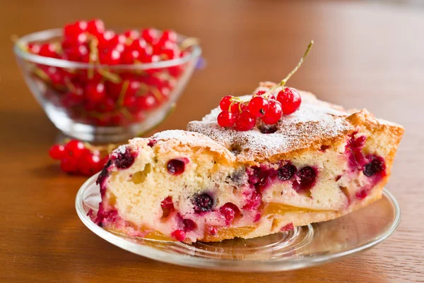 Piece of berry pie on saucer and red currants in bowl — Stok fotoğraf
