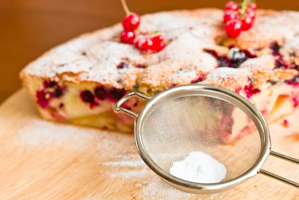 Sieve with powdered sugar and cake — Stock Photo, Image