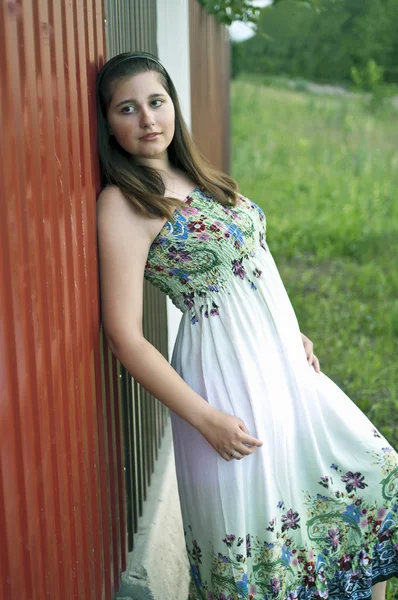 Metal çit karşı hafif elbiseli kız — Stok fotoğraf