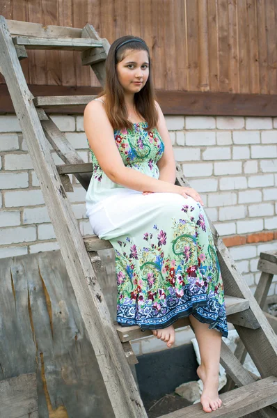 木製の梯子の上に座っている女の子 — ストック写真