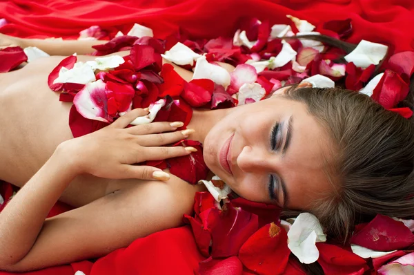 バラの花びらで眠っている少女 — ストック写真
