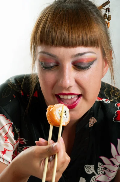 Жінка їсть суші каліфорнійський рулон — стокове фото