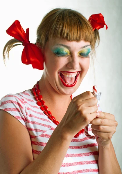 Смеющаяся девушка с полосатыми конфетами — стоковое фото