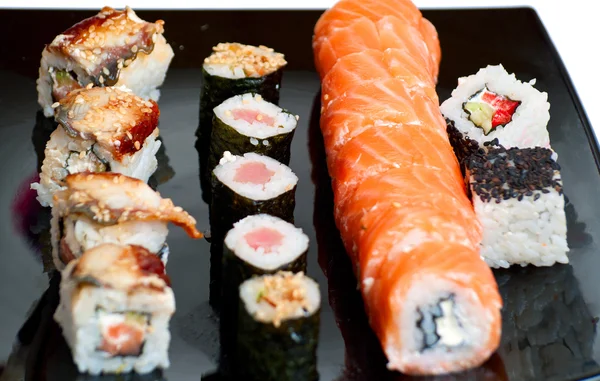Sushi rolls on a black plate — Stock Photo, Image