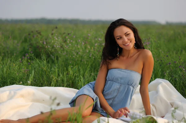 Девушка сидит на зеленой траве — стоковое фото