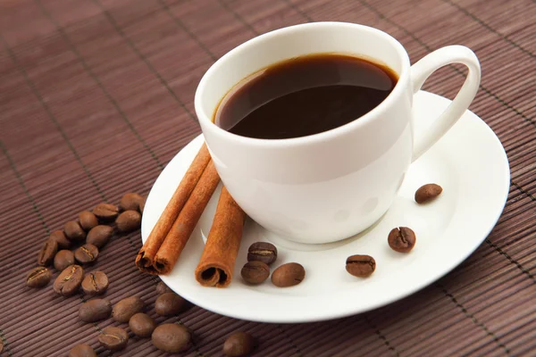 Cup of coffee with tubes of cinnamon — Stock Photo, Image