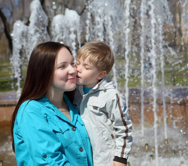 Ung pojke och hans mor promenader i parken — Stockfoto