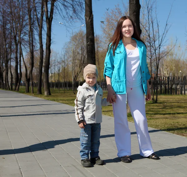 Giovane ragazzo e sua madre cammina nel parco — Foto Stock