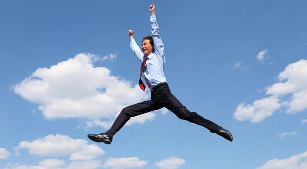 Прыгающий молодой бизнесмен в голубой рубашке — стоковое фото
