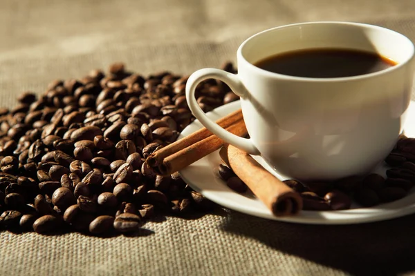 Чашка кофе с тюбиками корицы — стоковое фото