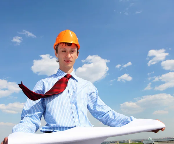 Jonge ingenieur in een blauw shirt en gele helm — Stockfoto