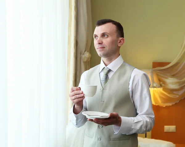 Νέος επιχειρηματίας κοντά στο παράθυρο πίνοντας τσάι — Φωτογραφία Αρχείου