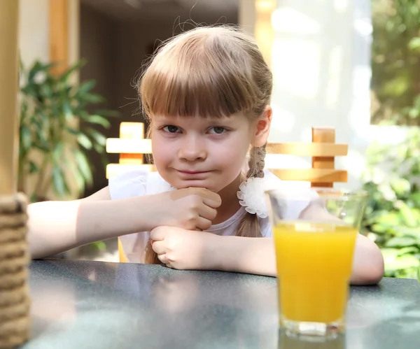 Portrait of little girl with orange juice — Stock Photo, Image